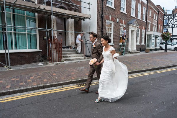 Bride and groom walking down road