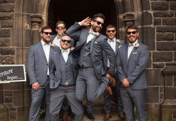 Best man jumping in front of groomsmen