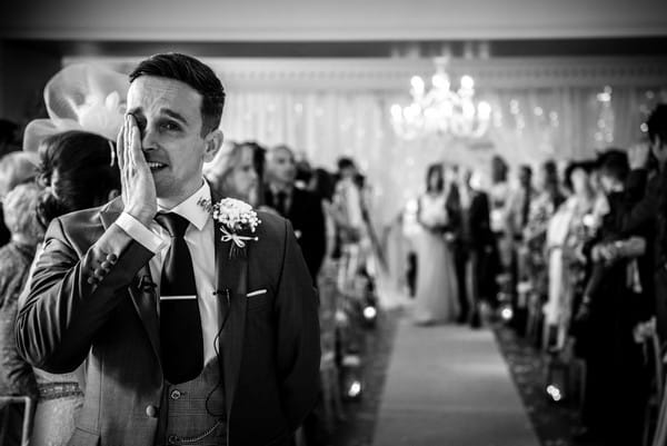 Emotional groom wiping tear from his eye as his bride walks down the aisle - Picture by James Tracey Photography