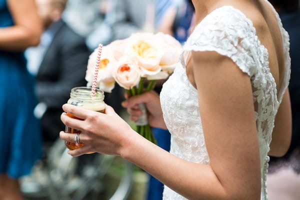 Bride holding drink in jam jar