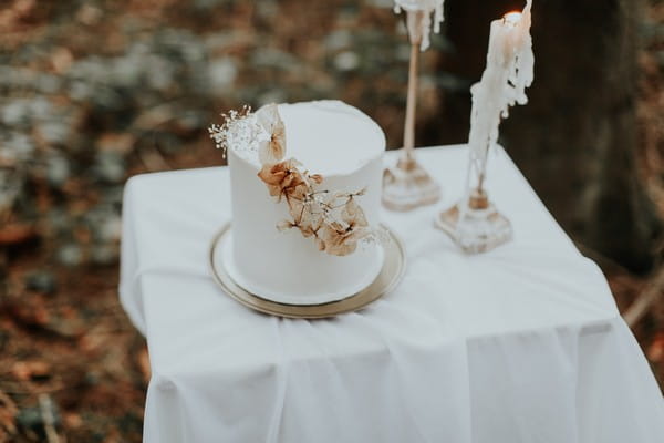 Natural dried flower detail on simple white wedding cake