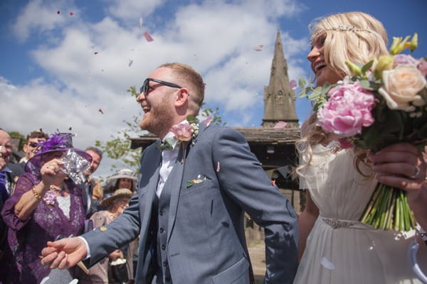 Bride and groom walking through confetti shower