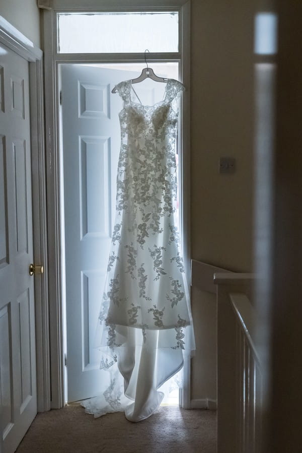 Wedding dress hanging in doorway