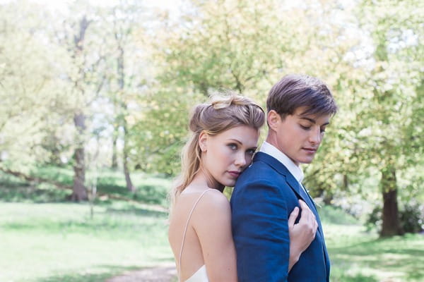 Bride hugging groom from behind