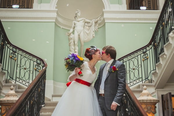 Bride and groom kissing on stairs at Sledmere House