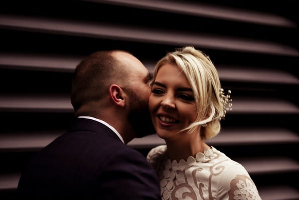 Groom whispering in bride's ear