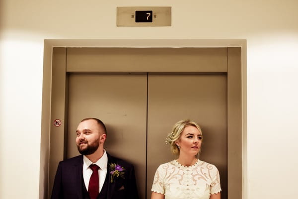 Bride and groom in front of lift at On the 7th