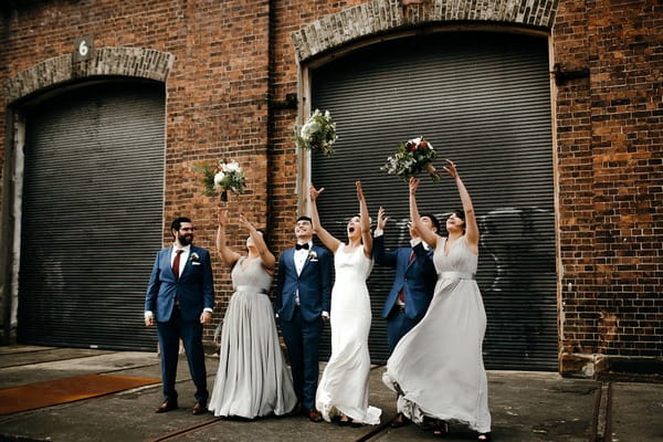 Bridesmaids throwing bouquets in air