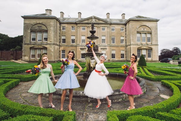 Bride and bridesmaids posing in front of Sledmere House fountain