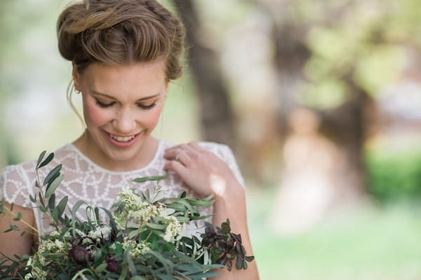 Bride looking down at bouquet