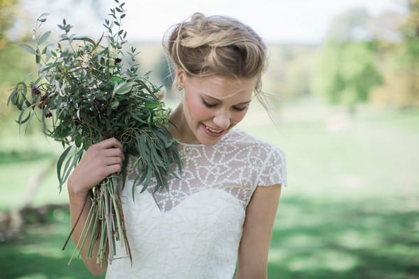 Bride holding bouquet to shoulder