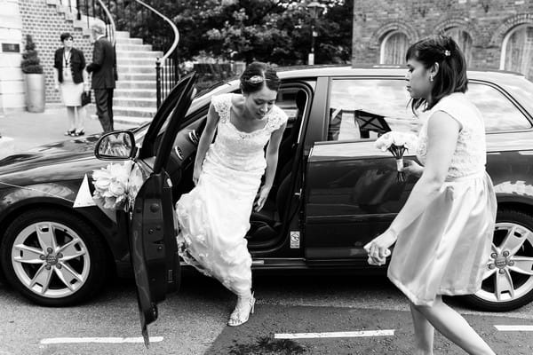 Bride getting out of wedding car