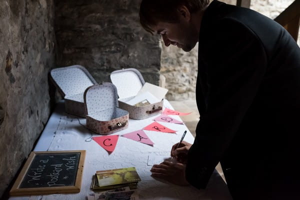 Wedding guest writing message to bride and groom