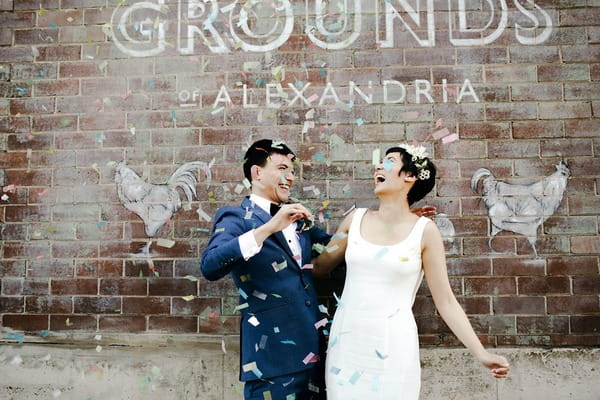 Bride and groom laughing after blowing confetti