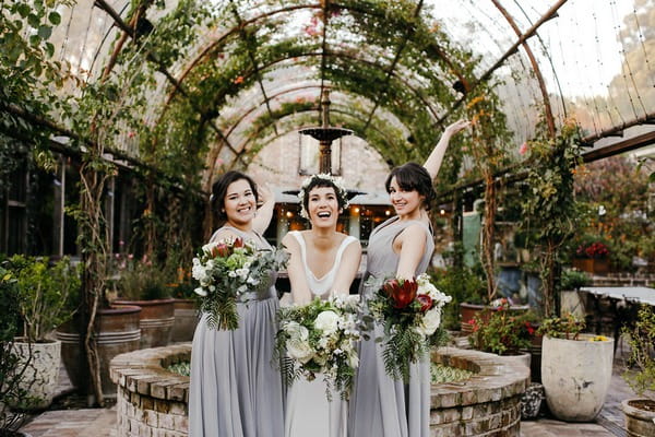 Bride and bridesmaids holding out bouquets