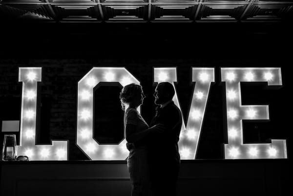 Bride and groom dancing in front of LOVE letters