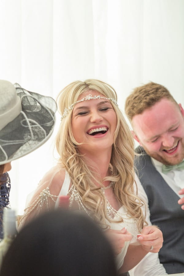 Bride laughing at wedding speech