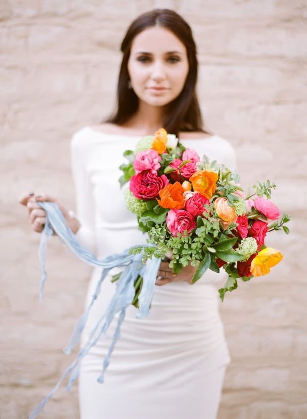 Bride holding brightly coloured bouquet