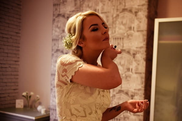 Bride putting perfume on