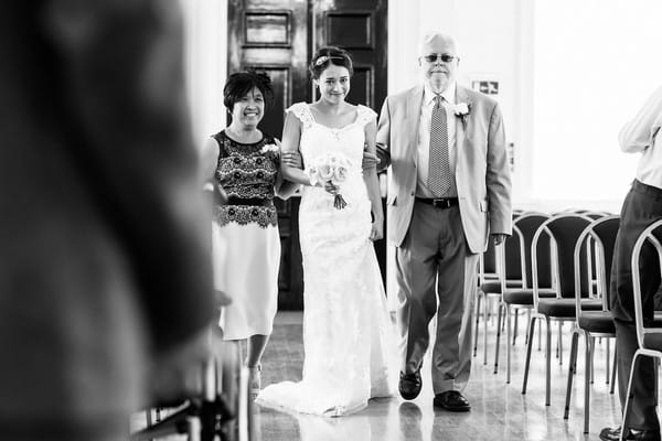 Mother and father walking bride down the aisle