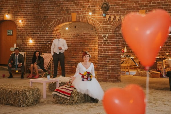 Bride sitting on hay bale listening to speech