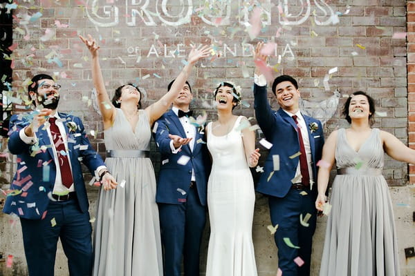 Bridal party throwing confetti in the air