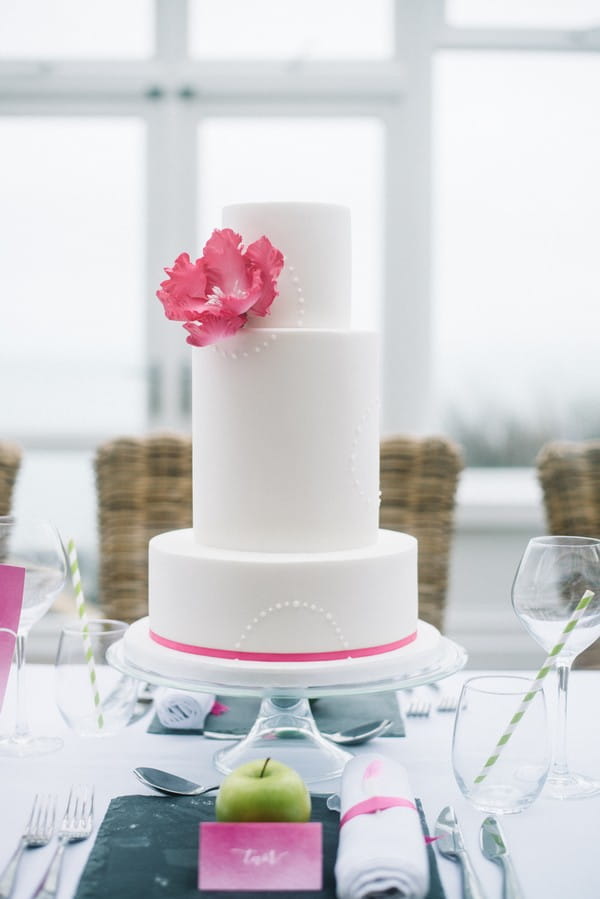 Wedding cake with pink flower and ribbon