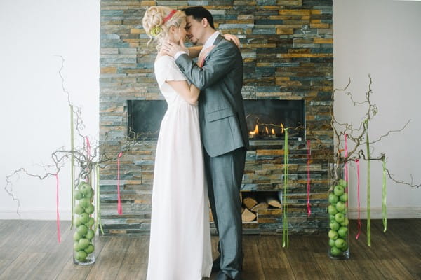 Bride and groom kissing in front of fireplace