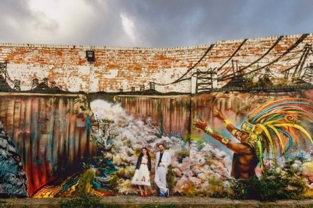 Bride and groom standing gainst graffiti wall - Picture by Lisa Carpenter Photography