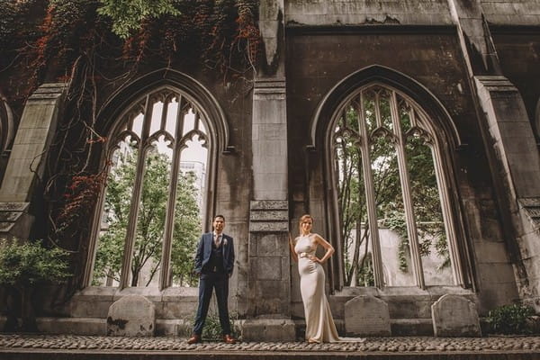 Bride and groom standing in front of ruin wall - Picture by Emma-Jane Photography