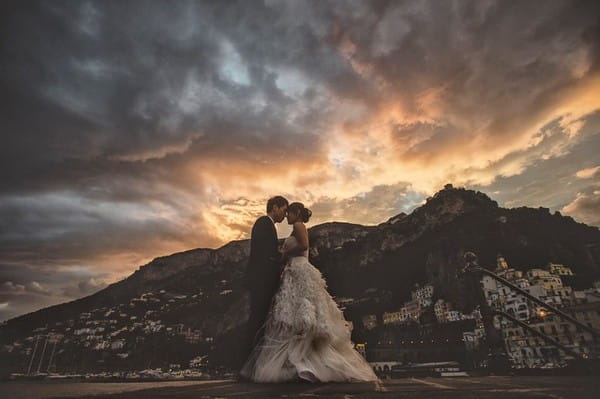Bride and groom with backdrop of Ravello, Italy, and dark clouds overhead - Picture by Gianni Di Natale Photographer