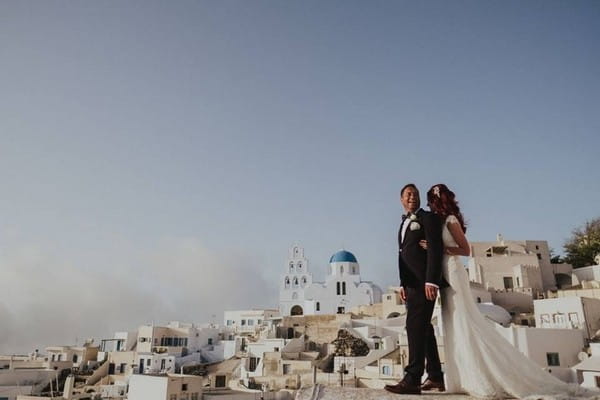 Bride and groom with the backdrop of Santorini - Picture by Steve Fuller Photography