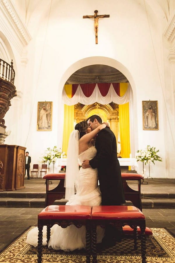 Bride and groom kiss in La Merced church in Guatemala