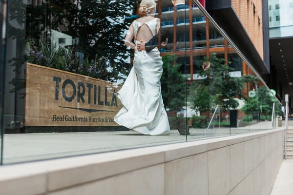 Bride and groom walking past restaurant