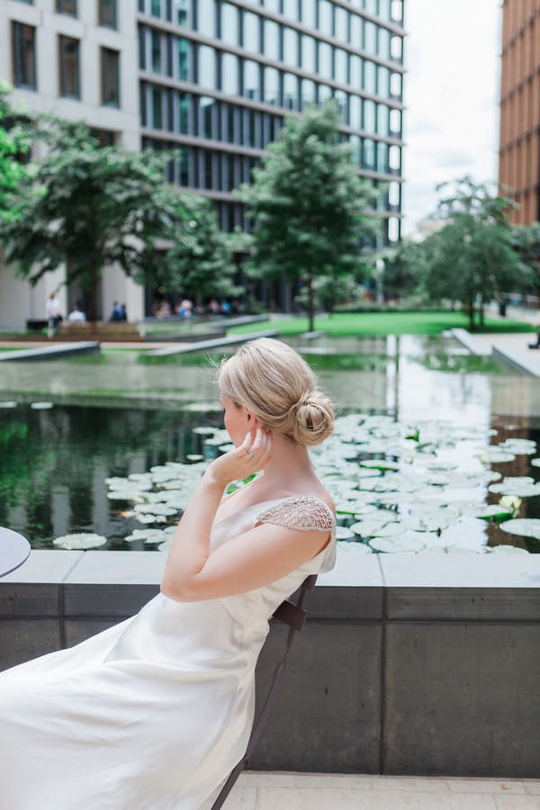 Bride sitting next to water feature in London