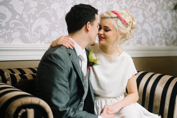 Bride and groom about to kiss on couch