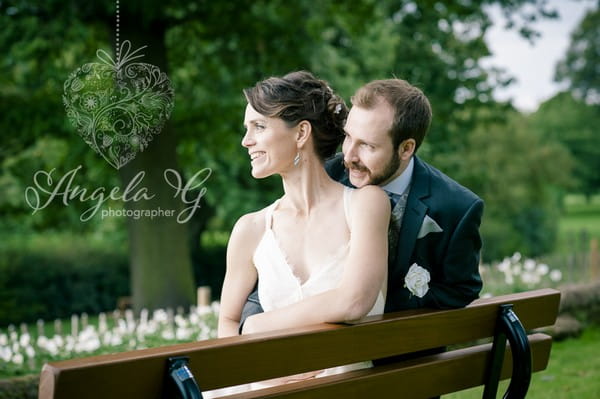 Bride and groom sitting on bench - Picture by Angela G Photographer