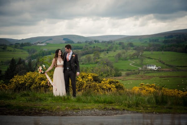 Bride and groom with backdrop of countryside hills - Picture by Elizabeth Baker Photography