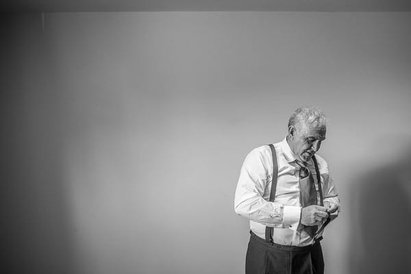 Elderly man adjusting braces before wedding - Picture by Damien Vickers Photography