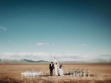 Bride and groom looking down at ground in California Salt Flats - Picture by India Earl Photography