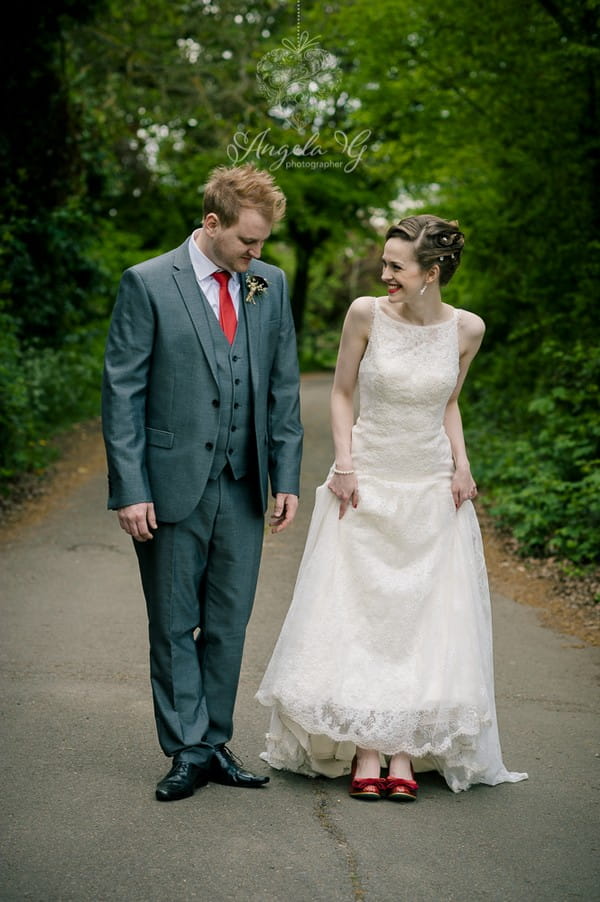 Bride pulling up dress to show groom her shoes - Picture by Angela G Photographer