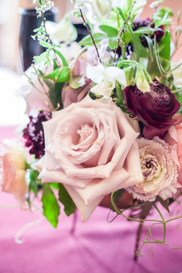 Close up of pink and purple wedding table flowers