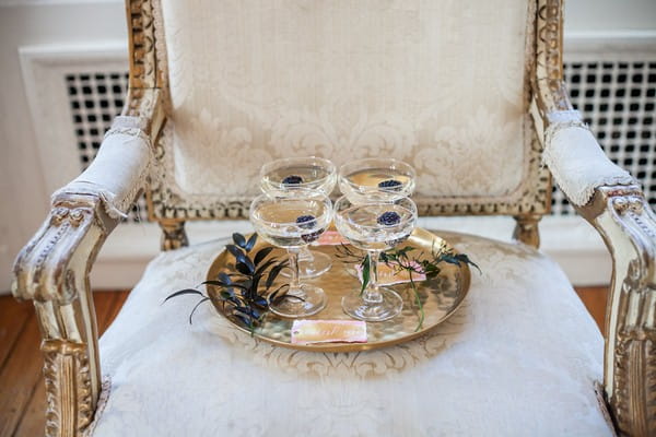 Glasses of champagne with blackberries on chair