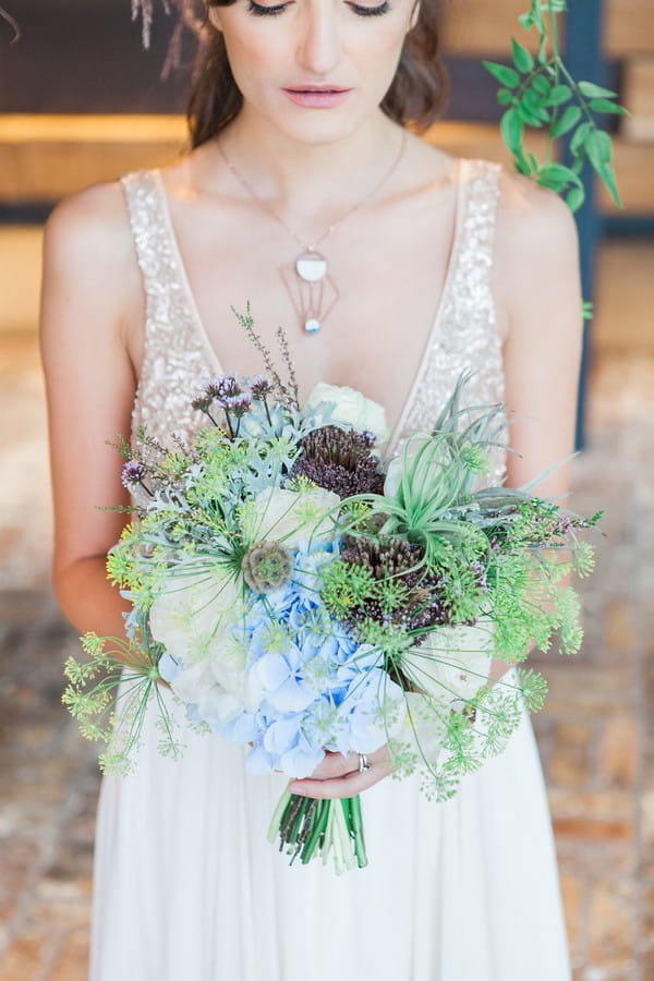 Bride holding wedding bouquet with lots of foliage