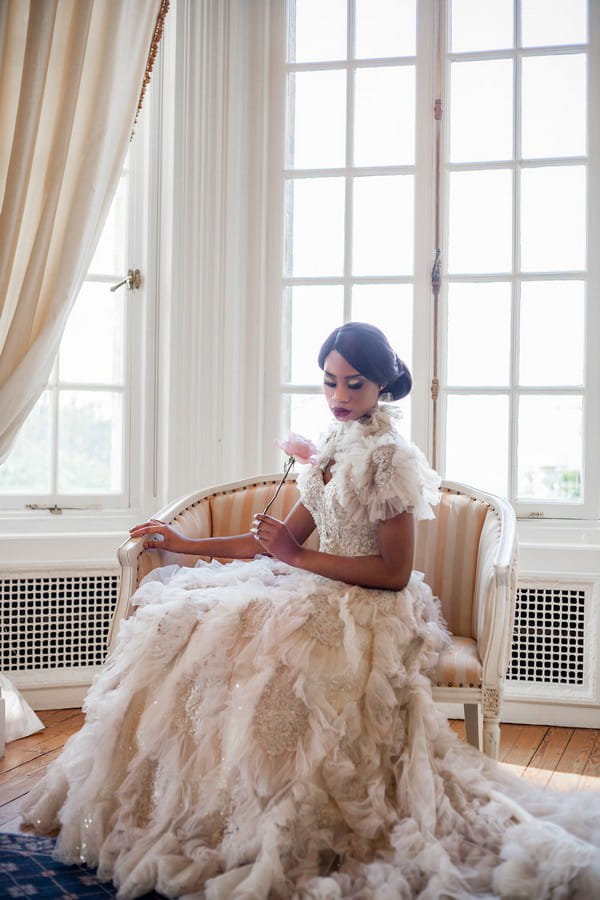 Bride sitting wearing wedding dress with ruffle detail