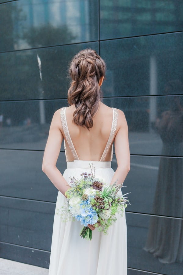 Bride holding bouquet behind back