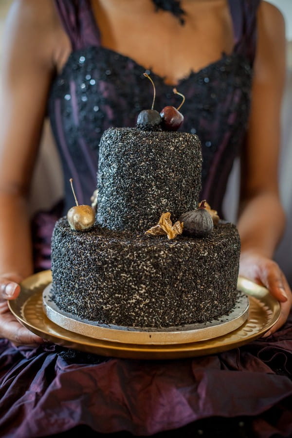 Bride holding black wedding cake