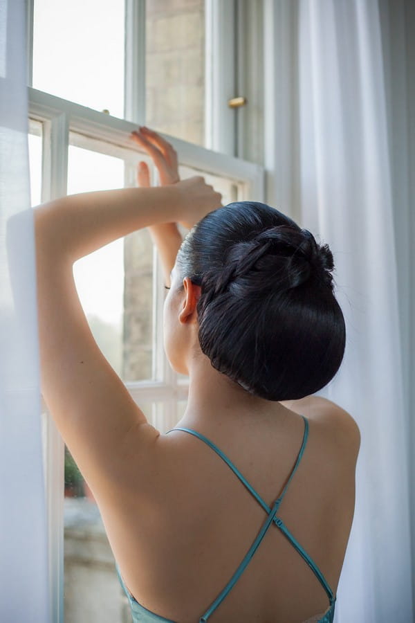 Bride with chignon hairstyle looking out of the window