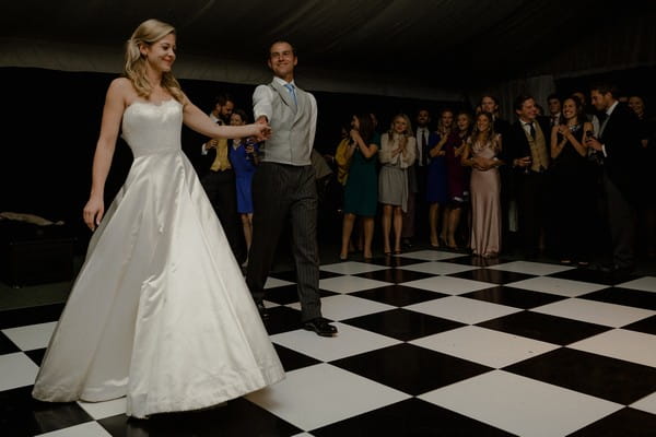 Bride and groom walking onto dance floor for first dance