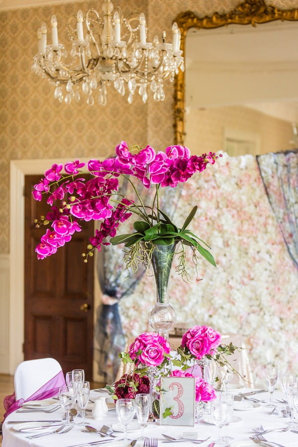 Bright Pink Wedding Table Flowers with Flower Wall Backdrop